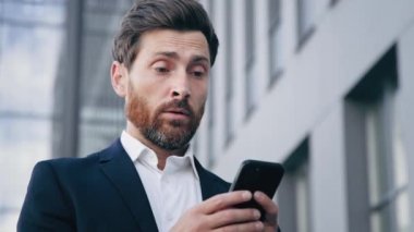 Dışarıda dikilen üzgün adam cep telefonundan olumsuz haberler alıyor. Umutsuz iş adamı bankadan kredi talebi alıyor. Kötü elektronik cihaz çalışmasından memnun değil.