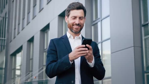 Усміхнений Чоловік Тримає Телефон Перевіряючи Повідомлення Електронної Пошти Читаючи Хороші — стокове відео