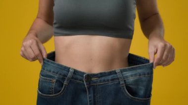 Kırpılmış manzarayı kapat. Tanınmayan ince atlet kız. Tanınmayacak kadar ince spor kadın. Büyük beden pantolon giyen, kilo kaybettiğini gösteren kadın.