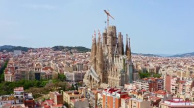 Barcelona, Spain - 13.09.2022: Aerial view shot from flying drone La Sagrada Familia cathedral temple holy church city landscape buildings panorama sky mountain background touristic place in Europe