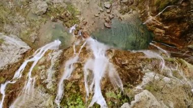 Aerial top view from above drone rock cliff rocky highlands mountains with falling fresh clean water waterfalls of Plitvice lakes national park in Croatia. Travel to Croatian waterfall Europe tourism