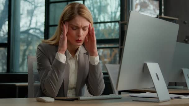 不満を持つ病気悲しい白人中年の大人の女性成熟したビジネス女性のビジネス女性の労働者コンピュータとオフィスでの雇用主は頭痛の痛み痛み痛み痛みの痛みの頭のストレスに苦しむ — ストック動画