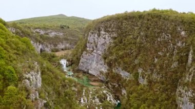 Aerial drone view mountains covered with green forest trees of Croatia top shooting from above Plitvice lakes waterfalls national park flight over rock. Tourism to wild nature of Europe tourist place