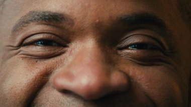 Extreme close-up view male eyes happy joyful african american man looking at camera pleased client satisfied with ophthalmology surgery or professional optical eye correction operation clinic services