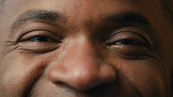 極端なクローズアップビュー男性の目幸せなアフリカ系アメリカ人男性カメラを見て幸せなクライアント眼科手術やプロの光眼補正操作クリニックサービスに満足 — ストック動画