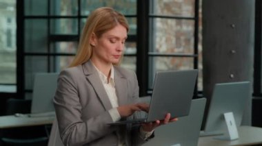 Business portrait in office female worker woman with laptop computer modern technology work. Adult middle-aged Caucasian businesswoman entrepreneur manager working in internet online smiling to camera