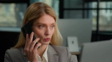 Caucasian middle-aged adult woman helpline agent client care service manager mature business female 30s businesswoman worker in office talking mobile phone call working computer talk with smartphone