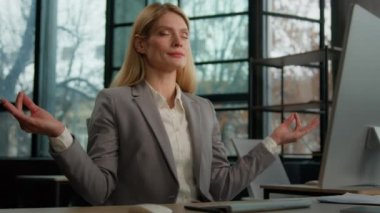 Calm Caucasian middle-aged adult woman mindfulness mature business female relaxed lady businesswoman entrepreneur worker employer in office at table meditating zen break relax in meditation no stress