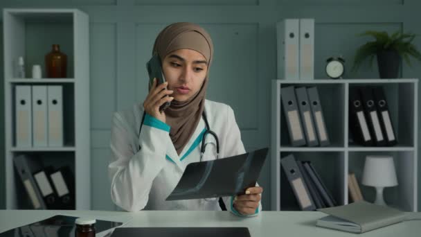 ヒジャーブ宗教における若い医師アラビア語トルコ人女性女性女性外科医療における女性放射線技師の仕事携帯電話を話すことは 患者の悪い断層撮影結果とX線骨折の画像共有を検討します — ストック動画
