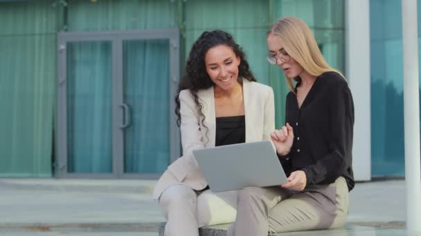 Friendly Young Caucasian Businesswoman Using Laptop Laughing Female Colleague Outdoor — Vídeo de stock