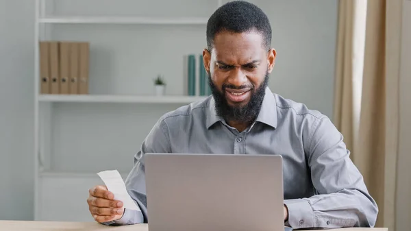African American ethnic man bearded businessman worried about financial troubles manage business company budget with calculator counting expenses check bill payment loan income finance money checking
