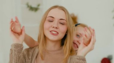 Caucasian small little playful cure small child kid baby girl daughter close eyes to mommy mother make surprise to shocked surprised wonder mom unexpected surprising cuddling hugging at home couch