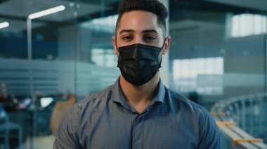 Close up headshot in office male business portrait ethnic multiracial multiethnic Hispanic Indian businessman manager entrepreneur executive guy worker man company CEO in medical protective face mask