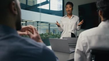 African American businesswoman mentor business coach company CEO female leader teaching business team multiracial diverse coworkers present startup project corporate training studying in office study