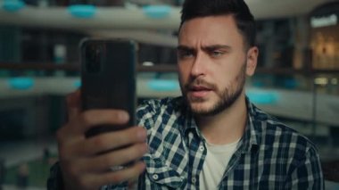 Millennial blogger caucasian hispanic man businessman business consultant speak mobile phone via digital webcam app on smartphone talk online friend business cell telecommunication use wi-fi network