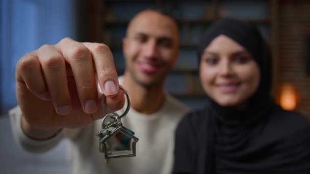 幸せな住宅所有者アフリカ系アメリカ人のアラビア人イスラム教徒の多民族多様性カップルは カメラ移転を見て新しい家の不動産からキーを示しています若い家族の概念のための銀行ローン住宅ローン — ストック動画