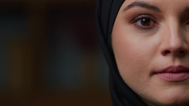 严重的女性半脸型阿拉伯穆斯林土耳其女人穿着传统的黑色头巾在室内摆姿势 头像镜头直射的中东女孩看着镜头近距离的肖像画伊斯兰民族典范健康的年轻女士 — 图库视频影像