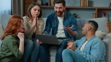 Ambitious team of friends colleagues diverse multiracial creative ethnic group gathered at home freelance develop online project on laptop discuss task share ideas good teamwork workflow cooperation