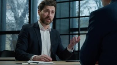 Businessman professional manager insurer consulting client about insurance benefits confident man leader sitting in office talking to business partner customer service manager salesman advises buyer