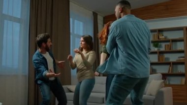 Four friends ethnic diversity multiracial caucasian hispanic african american women men adults female male roomamtes dancing together at home party funny dance to music celebrate event home relocation