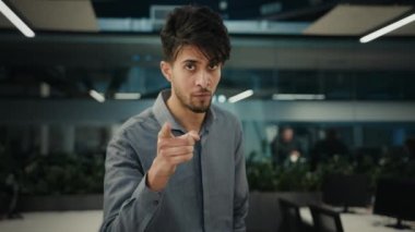 Indian 30s man businessman adviser smiling ethnic male entrepreneur office worker pointing index finger choosing you approve business idea support agree talking in online video conference webcam view