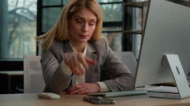 Tired sleeping exhausted napping businesswoman middle-aged Caucasian adult woman overworked employer female entrepreneur sleep sit at office desk workplace answer call talking phone typing computer