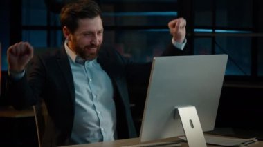 Happy Caucasian adult middle-aged businessman worker bearded man winner dancer active dancing in evening office celebrate end work having fun indoors singing moving victory dance funny moves to music