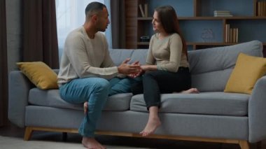 African american boyfriend holding hands girlfriend multiracial family couple in love sit on comfort couch. Caring man help beloved woman express empathy share romantic feelings psychological support
