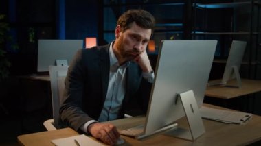 Bored yawning man Caucasian male businessman lazy office worker manager sit at desk indoors evening late night working with computer need nap sleep tired exhausted adult feel boredom lack of energy