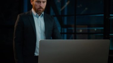 Caucasian businessman middle-aged adult man work at desk in evening office indoors focused worker boss employee typing on computer search data in internet using online banking app business commerce