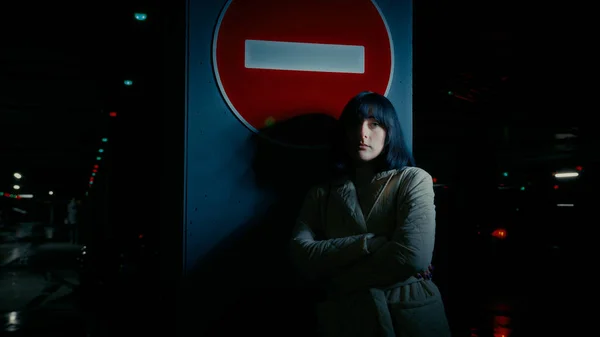 Sad upset stressed anxious depressed woman alone girl female lady standing at dark parking lot at night darkness near stop traffic road sign no drive thinking suffer feel stress depression despair
