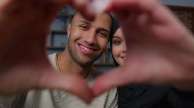 Newlyweds diverse ethnic married couple african american man with beloved arabian woman looking at camera through heart frame united husband wife hands in love shape Valentines Day romantic relation