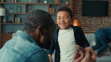 Afrikalı Amerikalı yetişkin baba oğul ile duygusal konuşma etnik çocuk çocuk çocuk gülüşmeler jestlerle konuşma evde iki çocukla eğlenme çocuklar aile bağı kurma oyunu oynamaktan zevk alıyorlar.