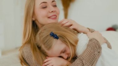 Mutlu, beyaz, sevgi dolu anne kucaklaşması. Sevecen, evlat edinilmiş, sevimli, bebek bakıcısı, sevimli anne, şefkatli aileyi kucaklayan küçük kızın başı.