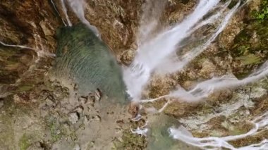 Aerial top view flying drone shooting beautiful waterfalls falling water from mountains rocks in Plitvice lakes national park Croatian lake in Croatia. Panoramic landscape of waterfall splash river