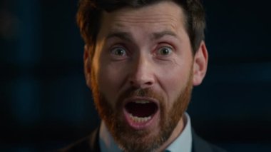Portrait surprised shocked Caucasian adult bearded businessman middle-aged 35s man happy employee manager worker stand in evening office rejoice good news win surprise positive emotion wonder delight