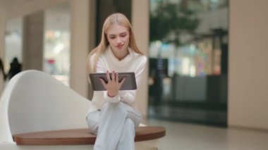 Serbest çalışan kadın serbest çalışan, alışveriş merkezinde oturuyor. Kafkasyalı iş kadını, internet mağazasının kadın müdürü. Alet dijital tablet kullanıyor.
