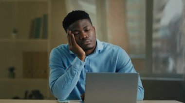 Bored tired exhausted businessman african american employee manager adult ethnic man sleeping office nap at desk lazy worker wake up answer mobile phone call talking distant with boss work on computer