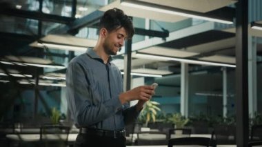 Arabian Indian businessman ethnic man professional office worker male guy use smartphone browsing mobile phone apps look at cellphone screen texting message business chat online make order in internet