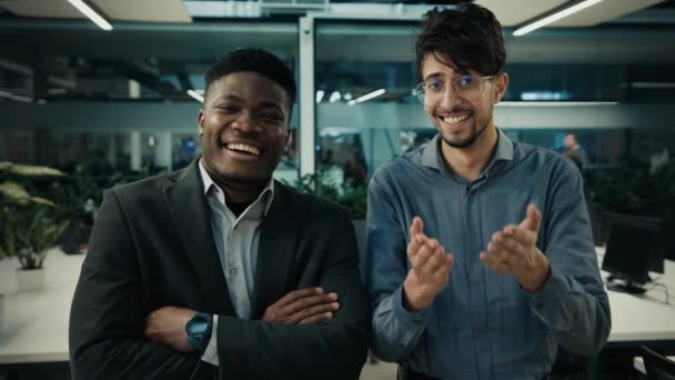 多様なビジネスマンの同僚ビジネスパートナー多人種間アフリカ系アメリカ人インド系アメリカ人の男性オフィスで折り畳まれた手で笑顔面白い冗談フレンドリーな肯定的なユーモアを笑って楽しい — ストック動画