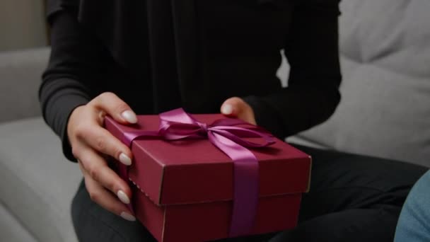 結婚記念日のバレンタインの愛の日に贈り物を提示することを閉じロマンチックな日付認識できない女性の手驚くべきピンクの箱を展開リボンを取る 二人の男と女がプレゼントされます — ストック動画