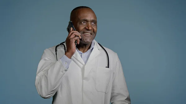 Mature African American Man Doctor Talking Phone Patient Blue Background — Stockfoto
