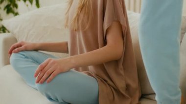 Düşünceli, sakin, bekar bir annenin kanepede oturup düşünceli, aktif bir kızın atlamasıyla ilgili meditasyon yaparken, beyaz bir annenin stres atmak için evde yoga meditasyonu yaparken, yaramaz küçük kızı rahatlatmak ve zıplamak.