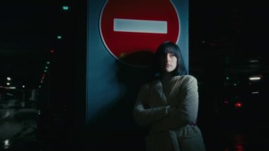 Sad upset stressed anxious depressed woman alone girl female lady standing at dark parking lot at night darkness near stop traffic road sign no drive thinking suffer feel stress depression despair