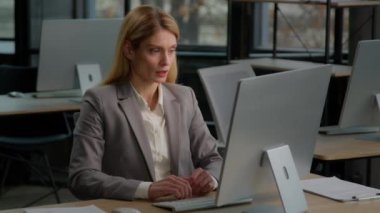 Caucasian middle-aged adult female corporate office worker with computer feel stress frustration work on desktop. Businesswoman executive manager woman working online worried with mistake failure lost