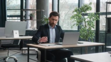 Odaklanmış yetişkin işadamı laptopuyla ofiste çalışır Kafkasyalı iş adamı lideri notları yazar profesyonel çalışan bilgisayar uygulaması ile internet yazma veri planlama bilgilerini analiz eder