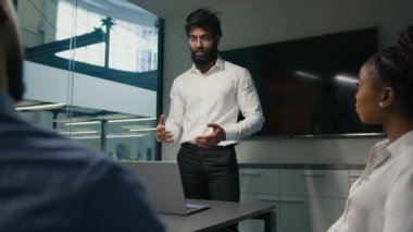 Arabian Indian businessman in glasses male leader man report share idea startup project presentation corporate training on office meeting multiracial business team applaud congratulation with success