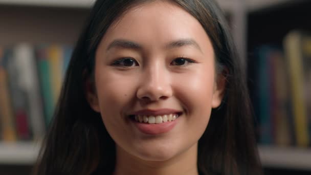クローズアップ若い幸せな自信を持って韓国の実業家女子学生教師図書館でカメラを見て楽しい女性クライアント笑顔で歯を満足サービスポーズだけで室内女性の肖像画 — ストック動画