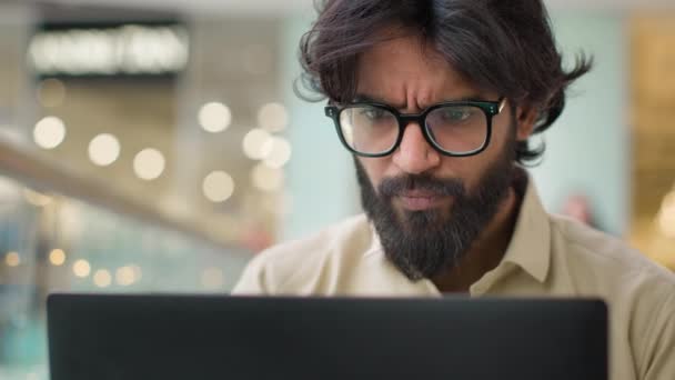 Серйозний Індійський Чоловік Окулярах Дивиться Екран Ноутбука Працює Інтернеті Закрийте — стокове відео
