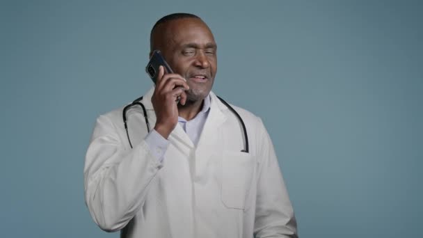 Dojrzałe Afryki Człowiek Lekarz Rozmawia Przez Telefon Pacjentem Niebieskim Tle — Wideo stockowe